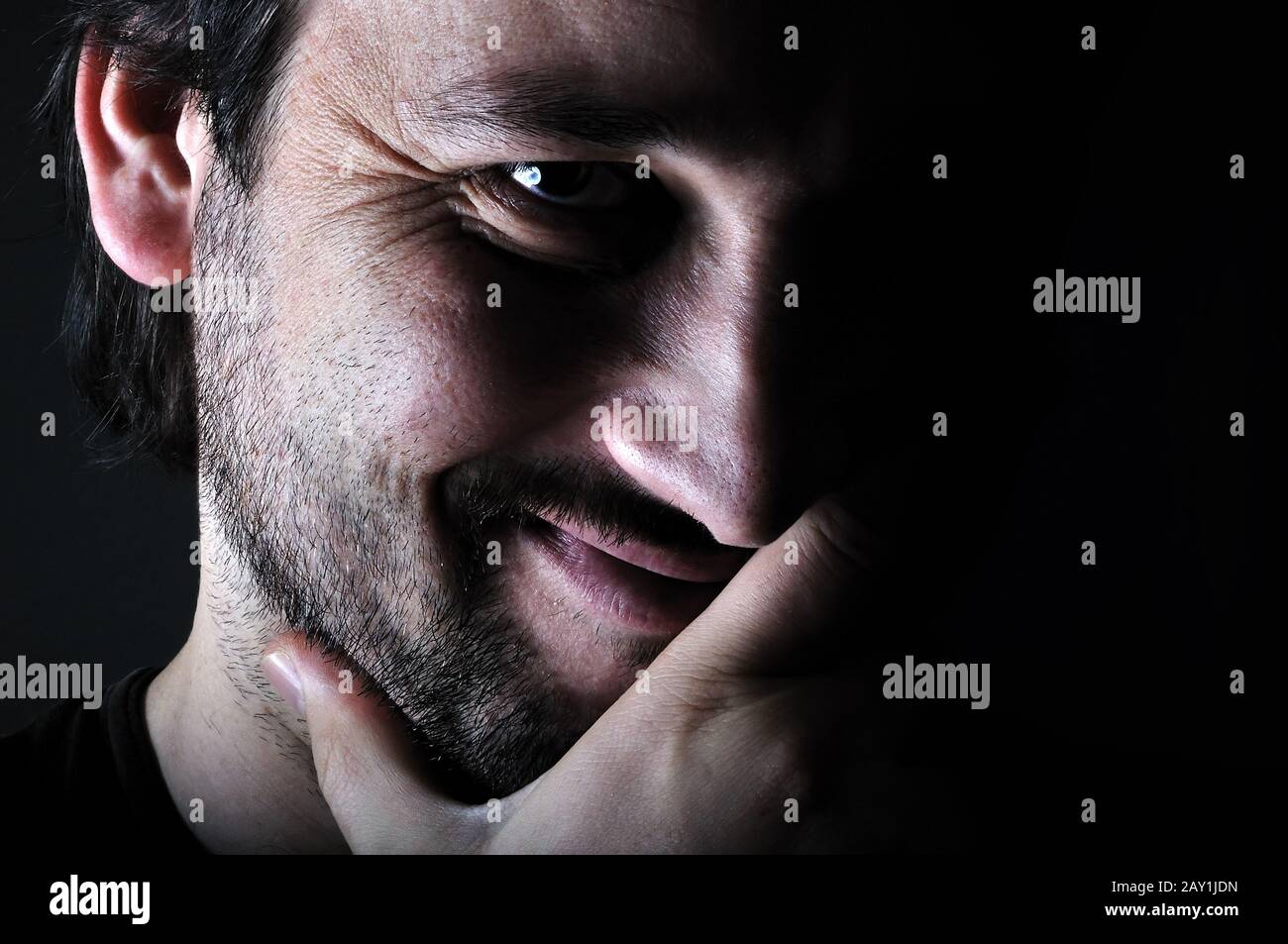 Young man smiling in the dark Stock Photo
