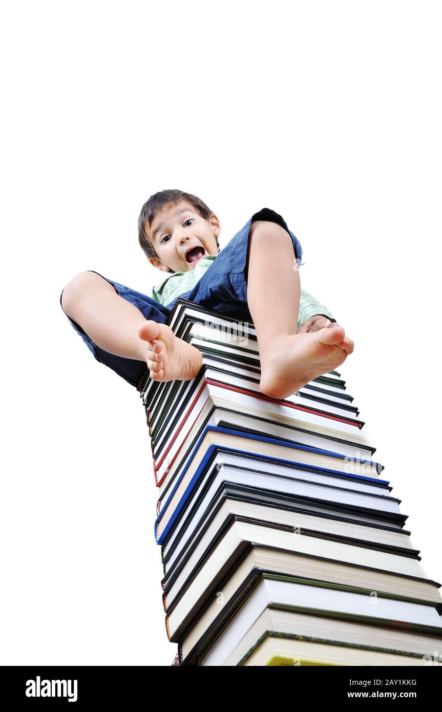 Cute little boy sitting on heap of textbooks Stock Photo - Alamy