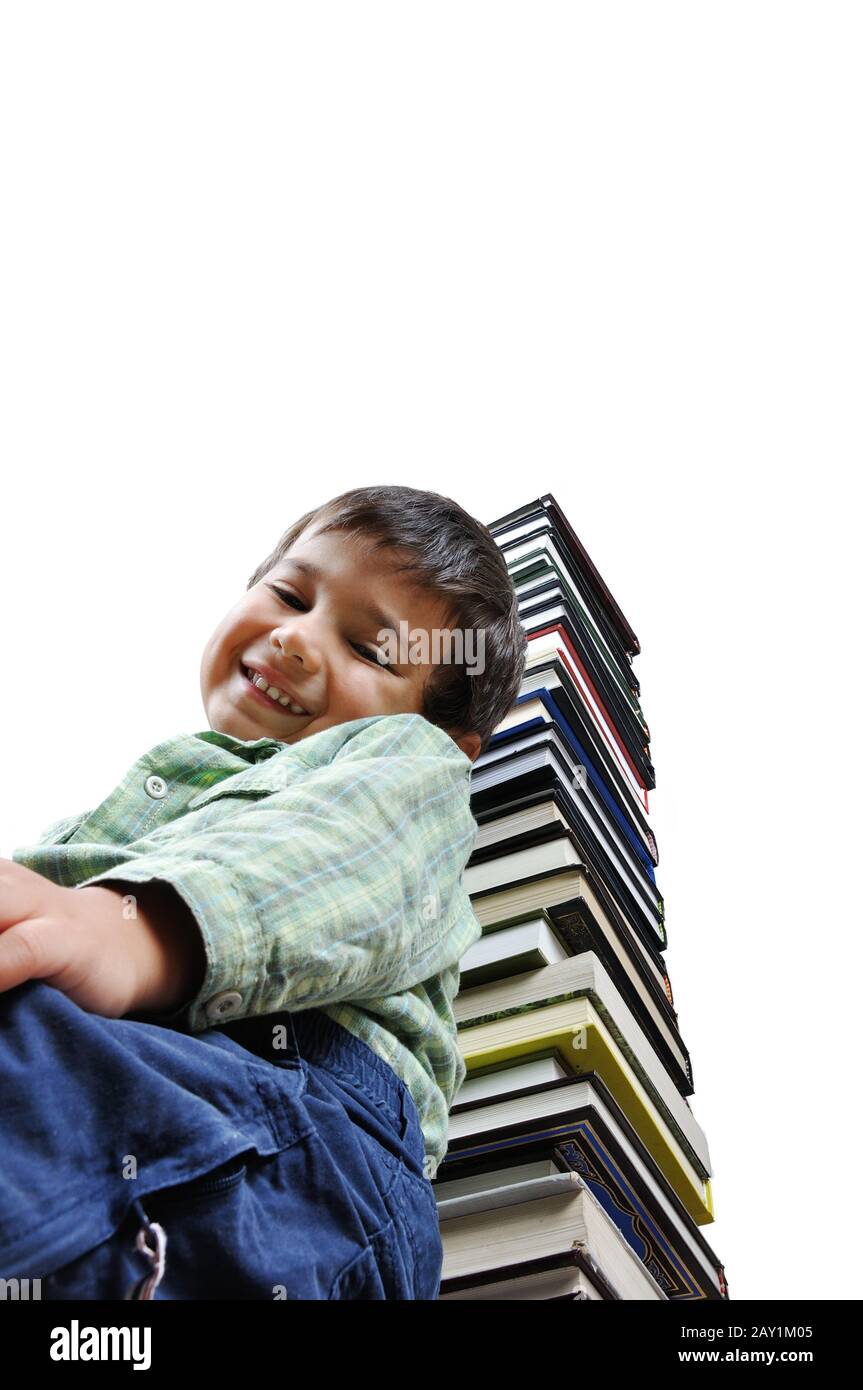 Image of a schoolboy in front of a big stack of books Stock Photo - Alamy