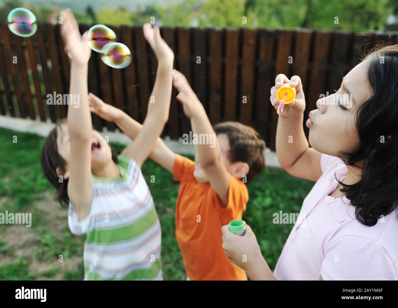 Happy children playing with bubbles outdoor Stock Photo - Alamy