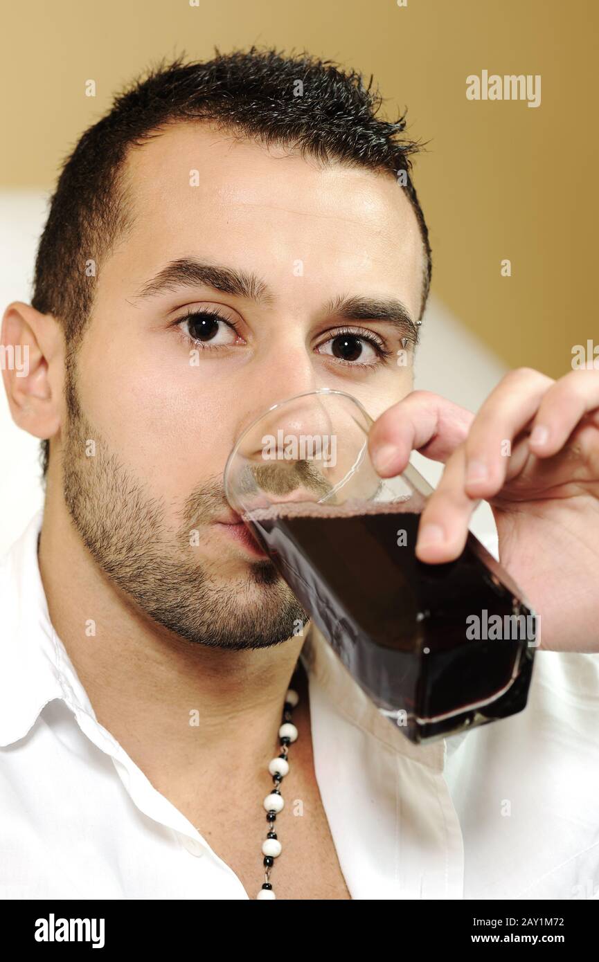Young attractive man drinking cherry juice Stock Photo