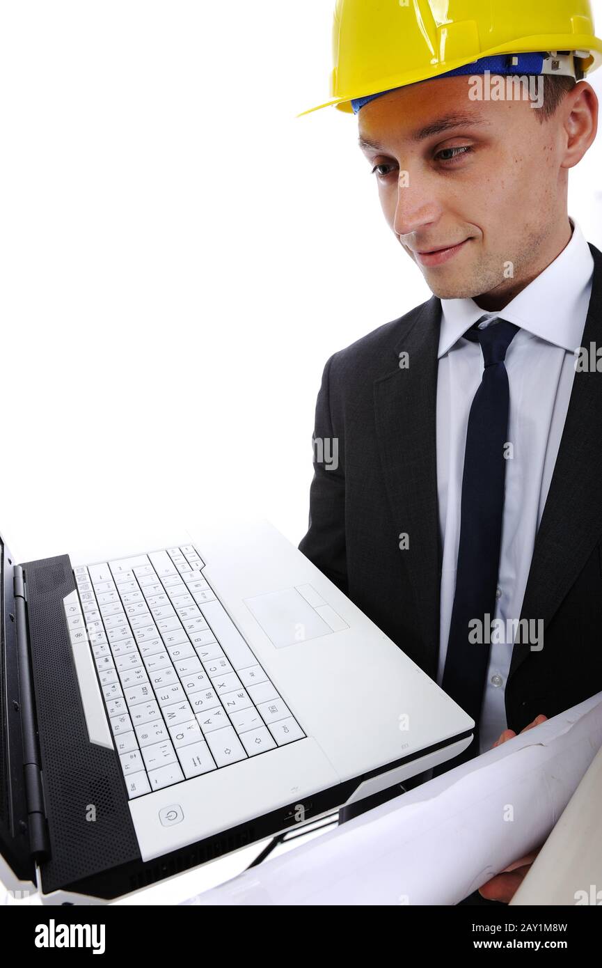 Construction engineer using his laptop computer and blueprints in the job Stock Photo