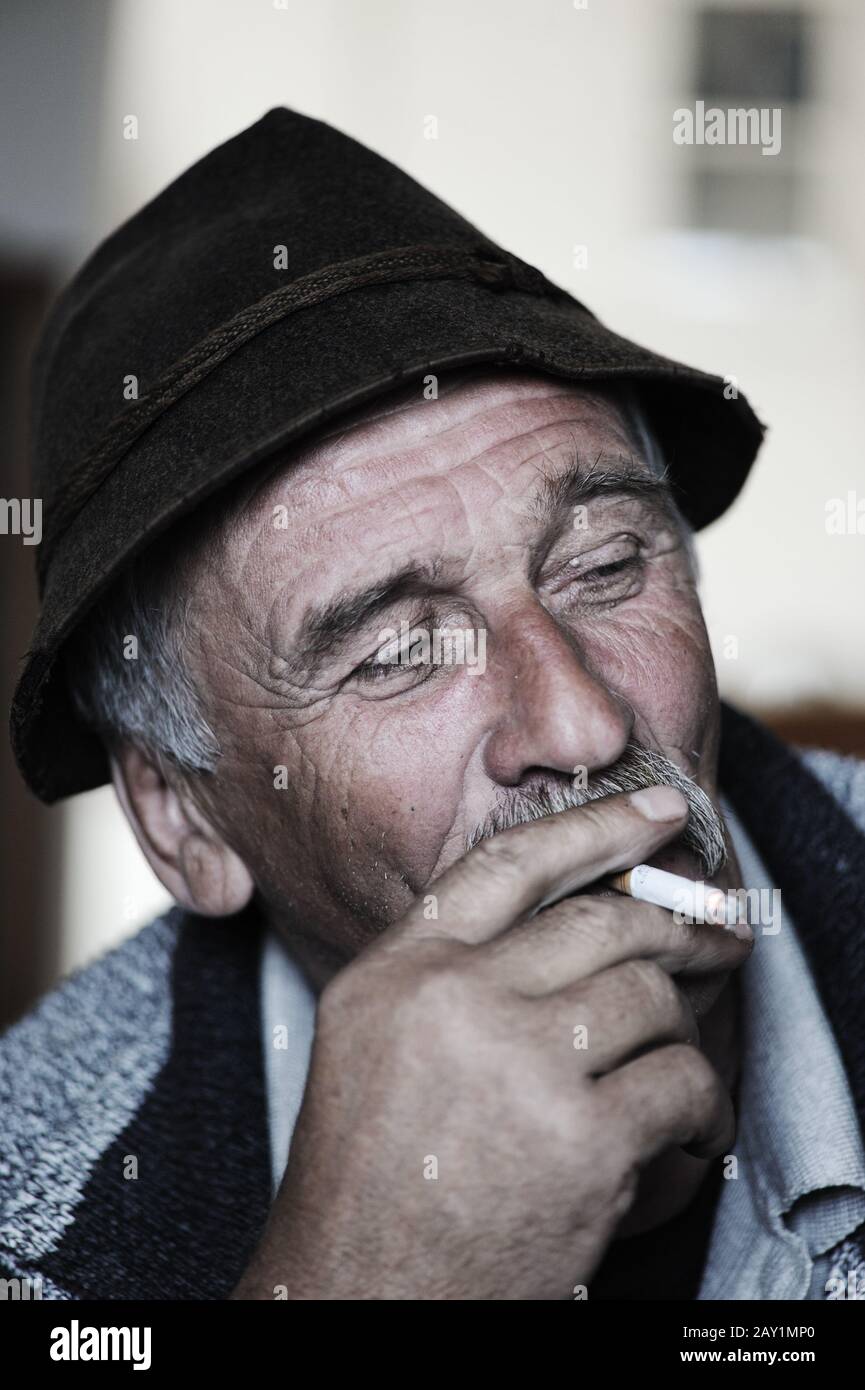 Closeup Artistic Photo of Aged Man With  Grey Mustache Smoking Cigarette Stock Photo