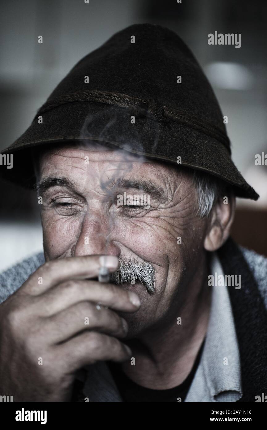 Closeup Artistic Photo of Aged Man With  Grey Mustache Smoking Cigarette Stock Photo
