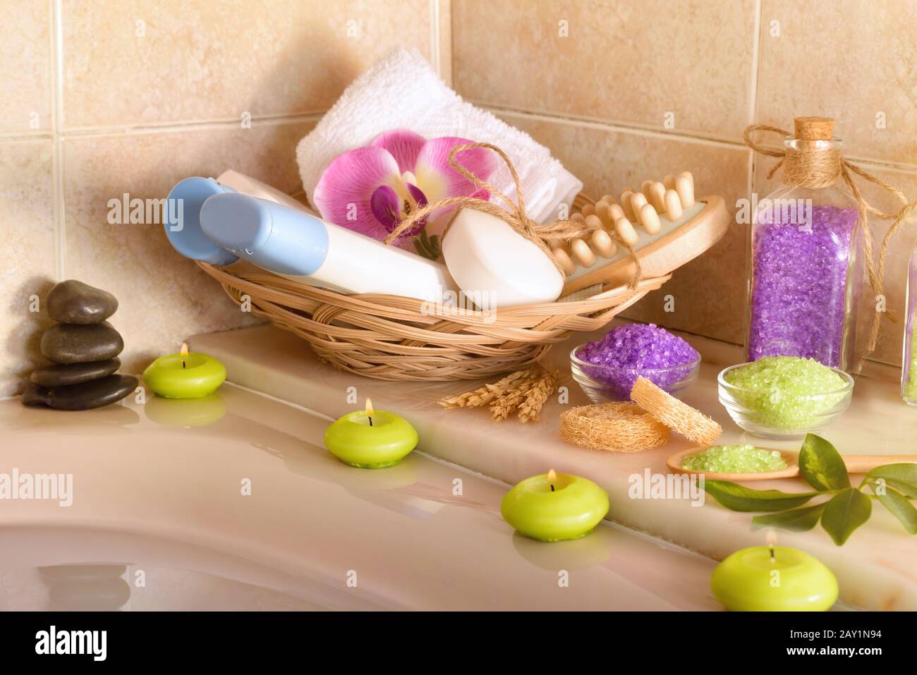 Skin care products in the bathroom. Gel, shampoo and salts and bath tools  in basket next to a whirlpool full of water. Front view. Horizontal  composit Stock Photo - Alamy