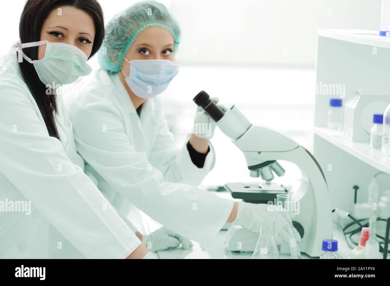 Two female scientists working at the laboratory with microscope Stock Photo