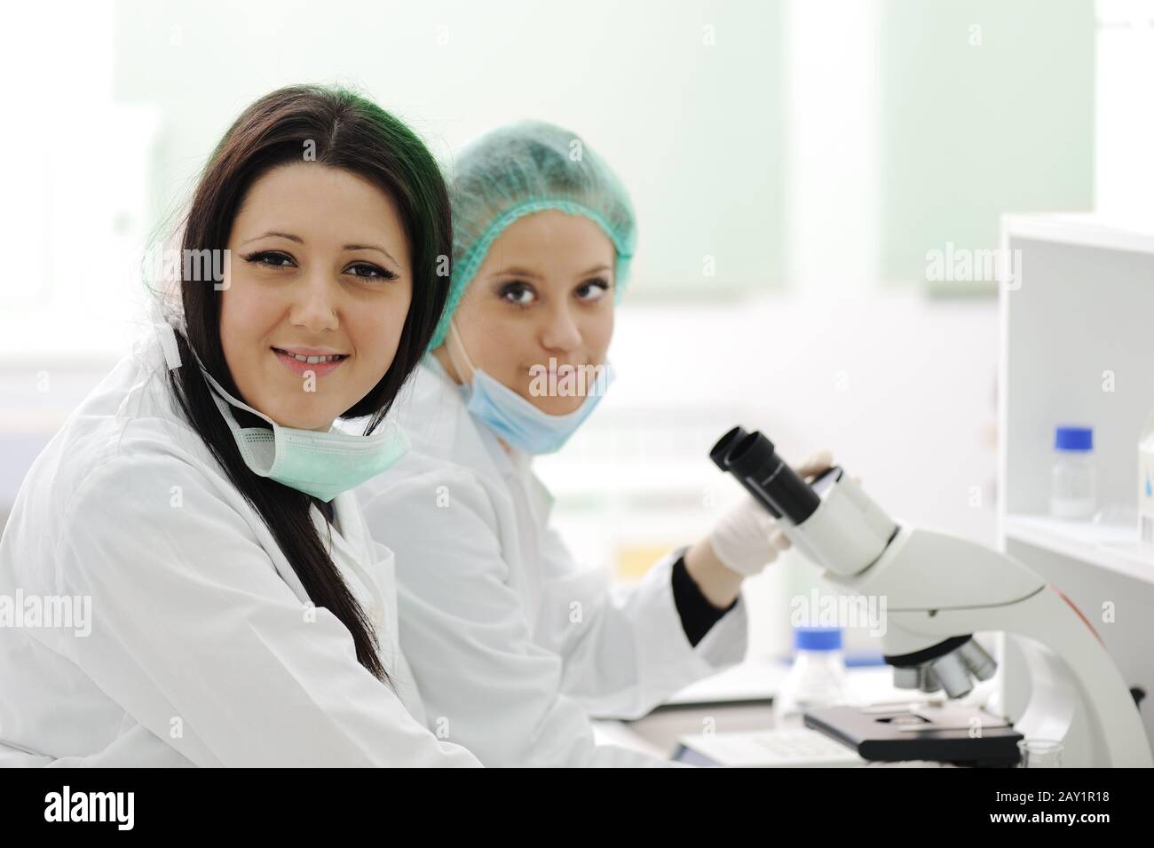 Two female scientists working at the laboratory with microscope Stock Photo