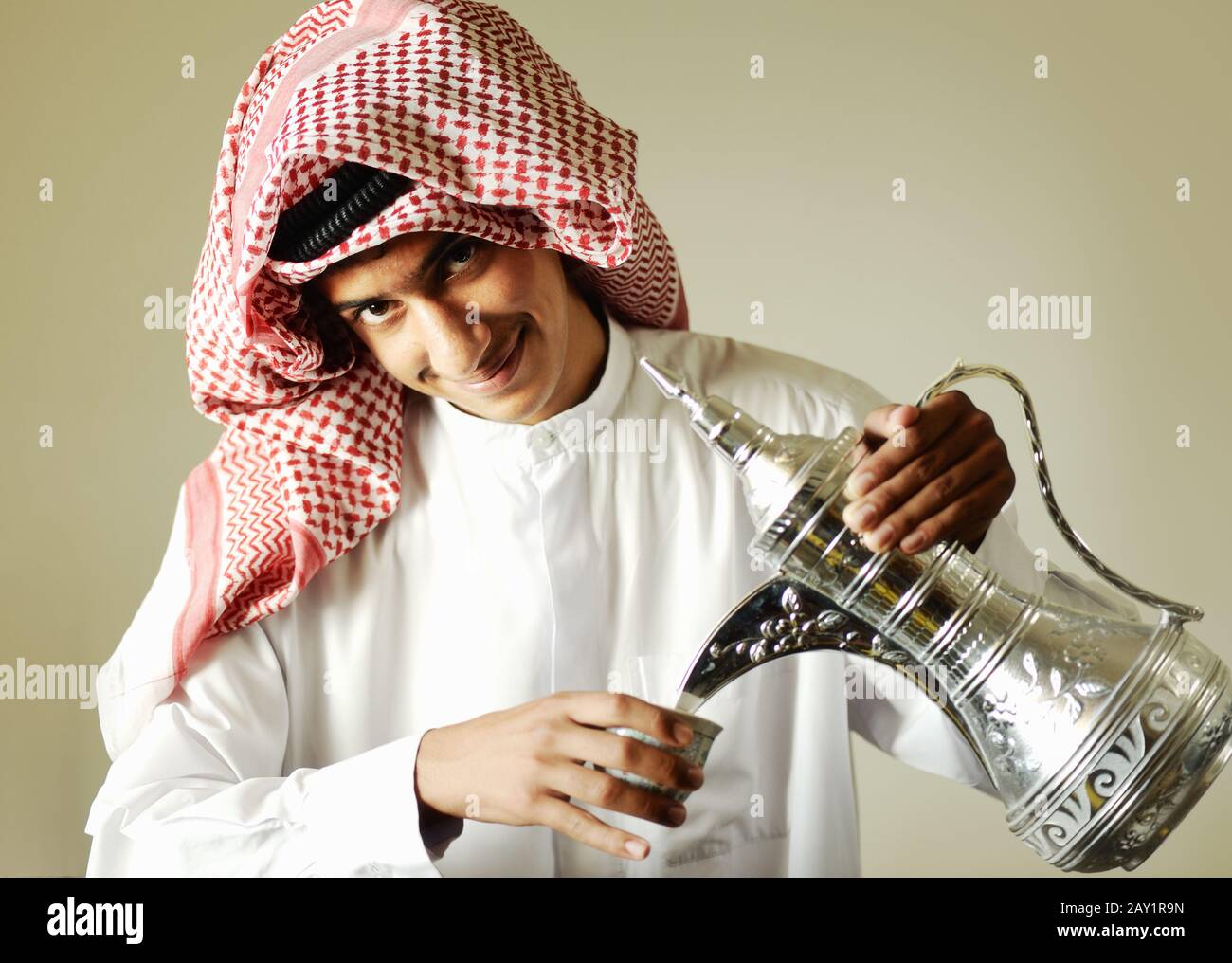 Arabic young man pouring a traditional coffee Stock Photo Alamy