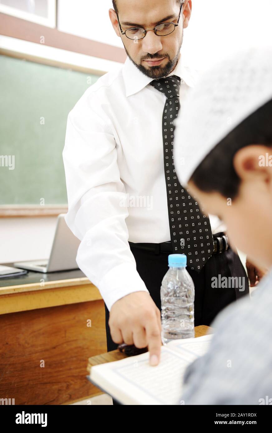 Young teacher helping a student in classroom Stock Photo