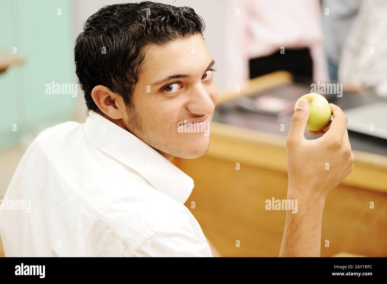Student in collage with an apple in hand smiling Stock Photo