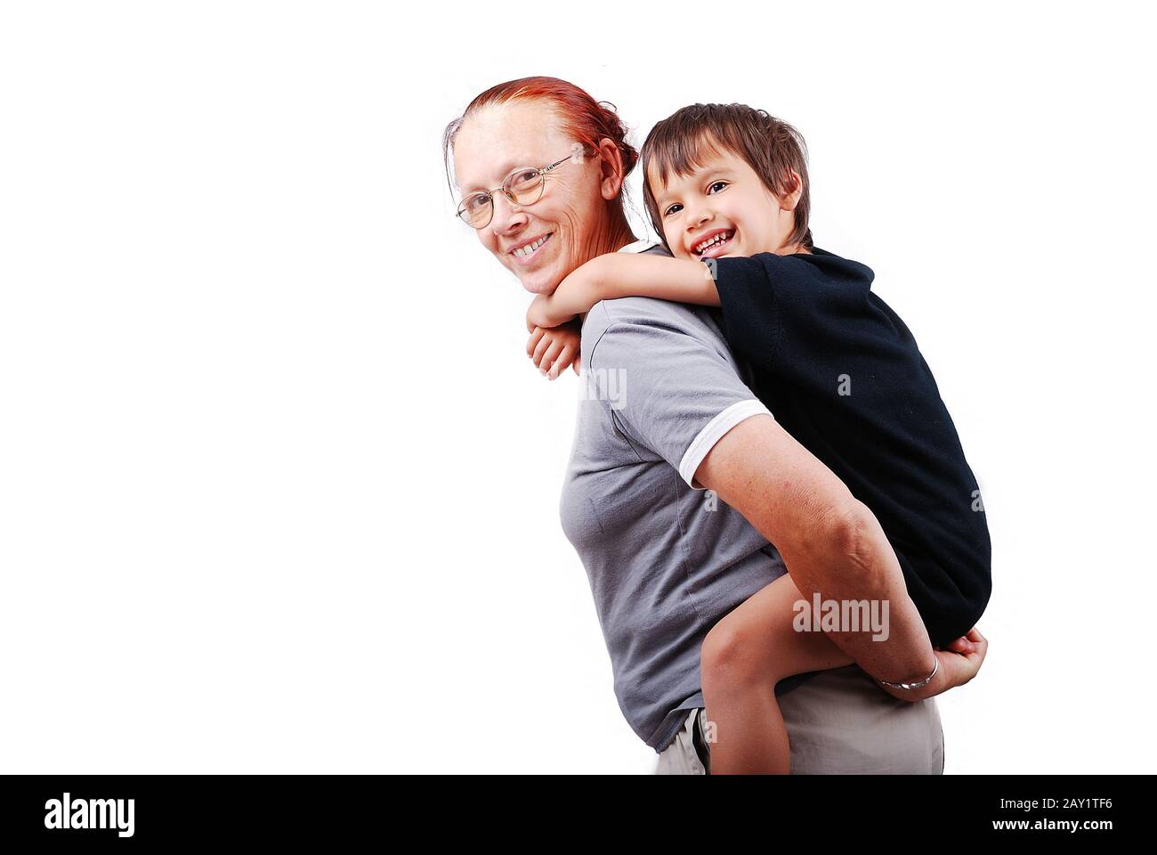 Middle aged woman holding little boy on her back Stock Photo