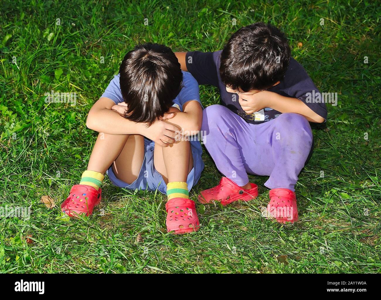 Two cute children sitting on ground Stock Photo