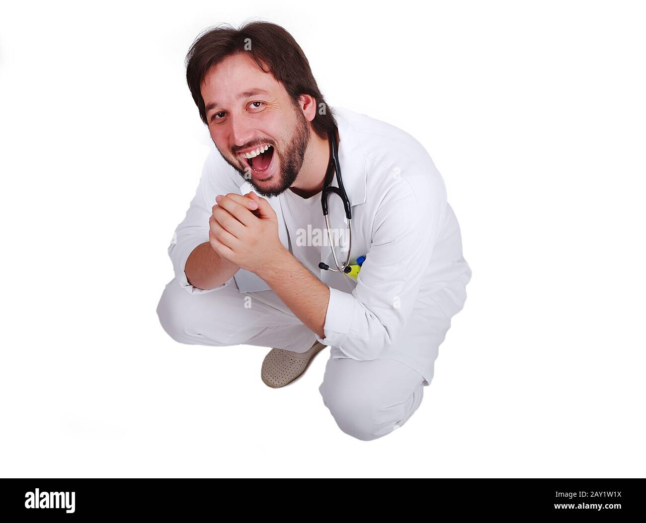 Young male doctor sitting down and laughing Stock Photo