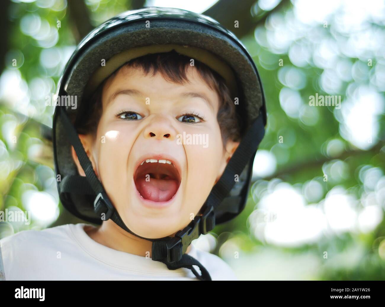 Little very cute kid with helmet on head and opened mouth Stock Photo