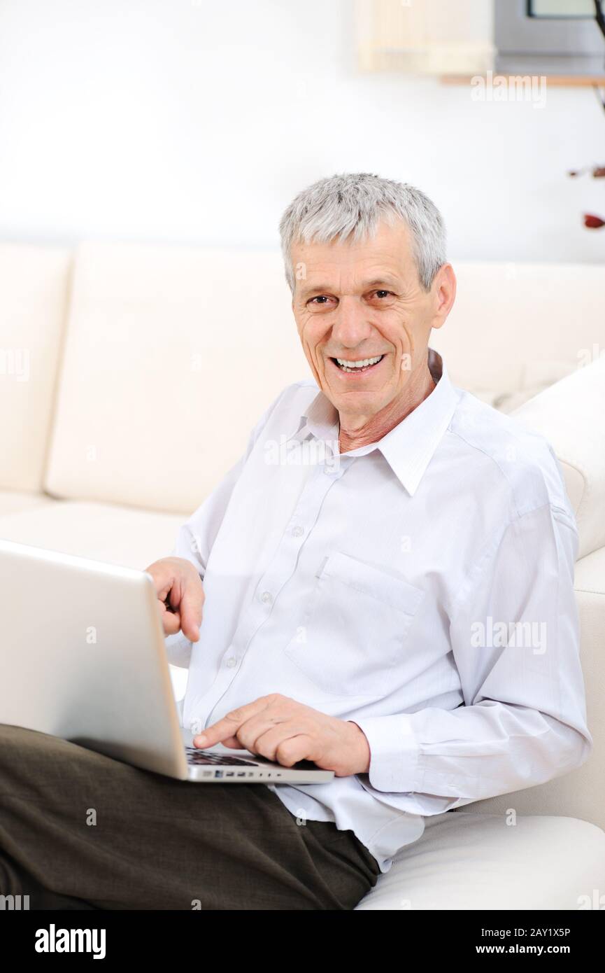 Senior good looking man with laptop at home Stock Photo