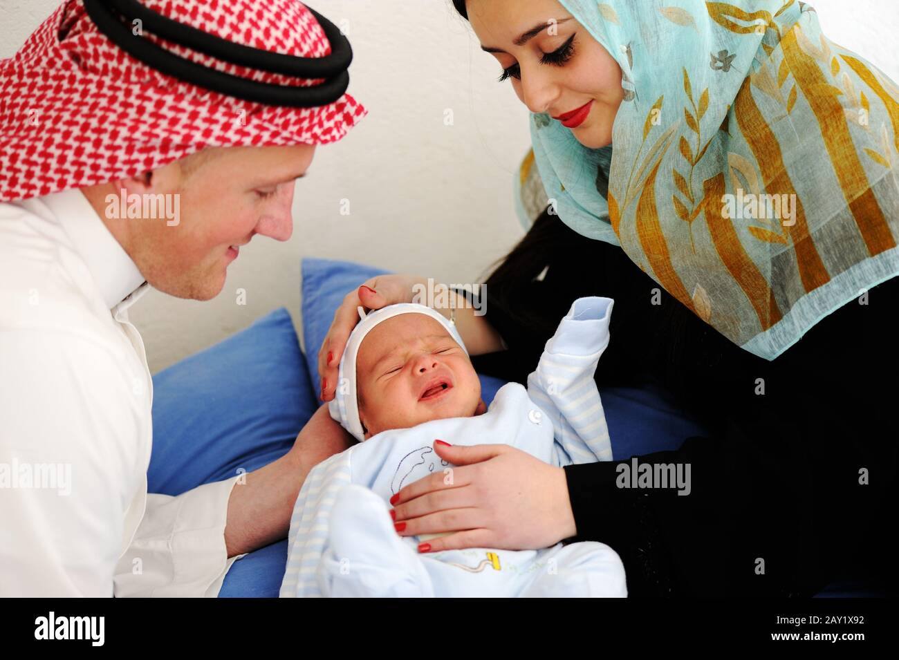 Arabic Muslim couple with new baby at home Stock Photo