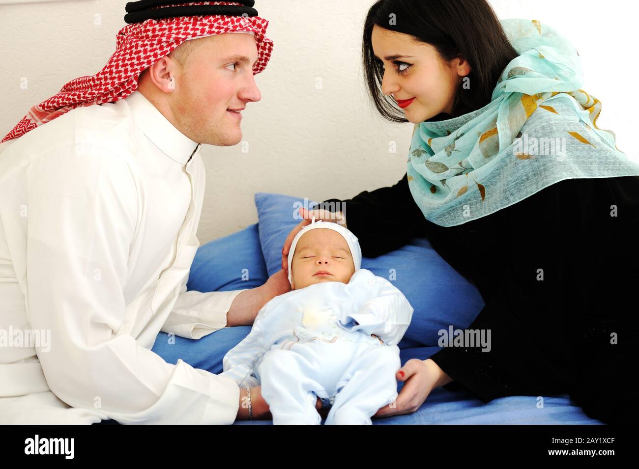 Arabic Muslim couple with new baby at home Stock Photo