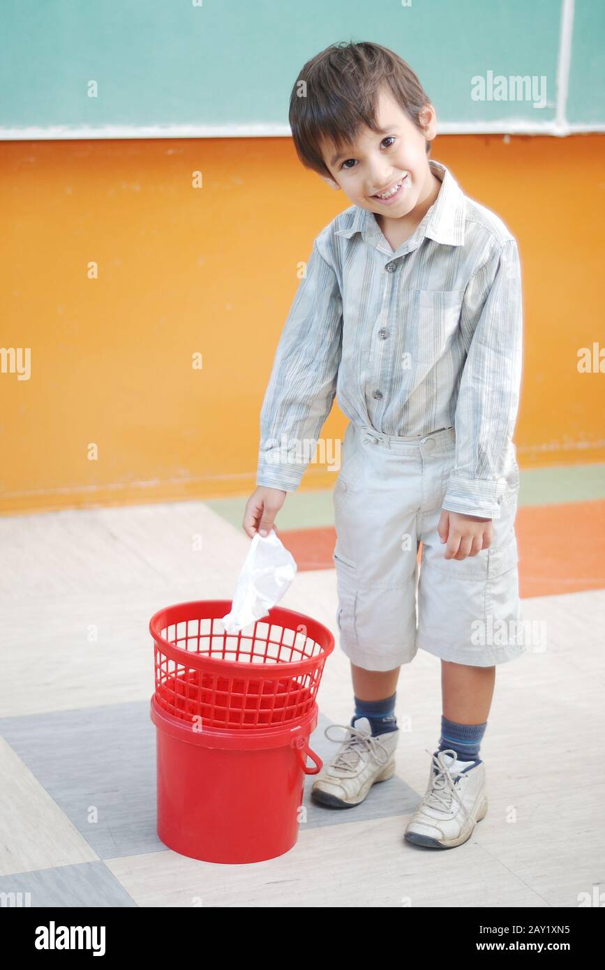 Little cute boy throwing paper in recycle bin Stock Photo