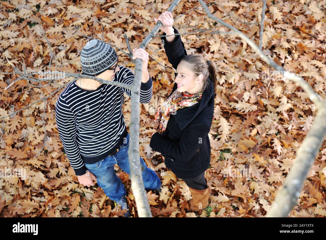 Romantic Teenage Couple By Tree In Autumn Park Stock Photo - Alamy