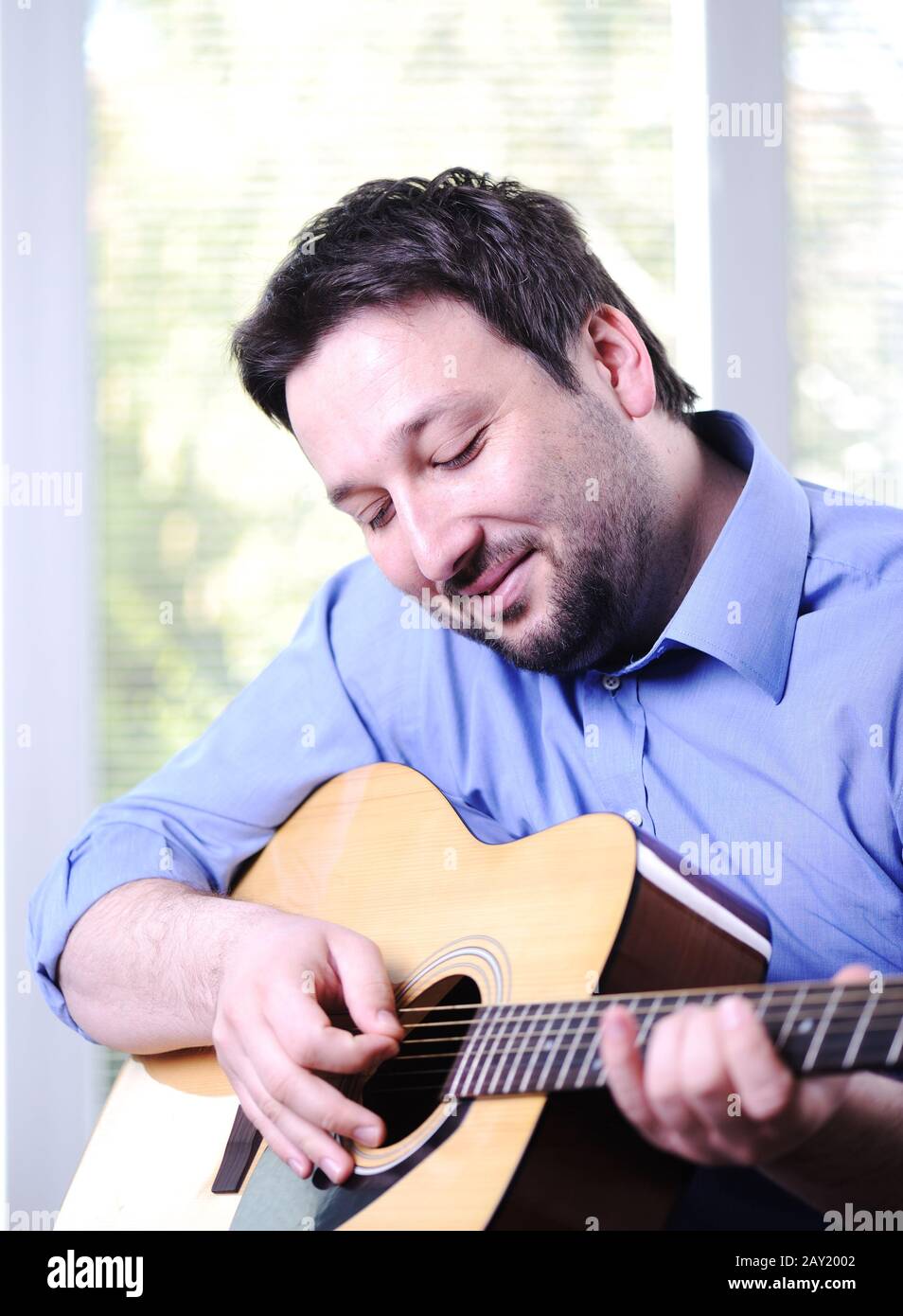 Man playing guitar and relaxing at home Stock Photo