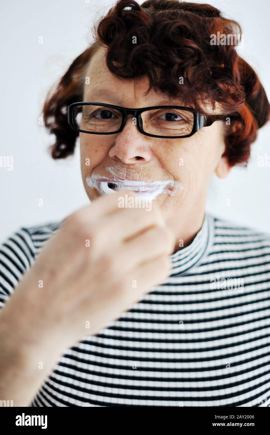 Elderly woman brushing teeth Stock Photo