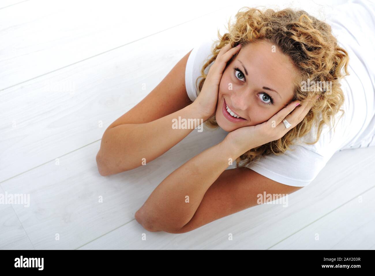 Happy young girl lying on floor at home Stock Photo - Alamy