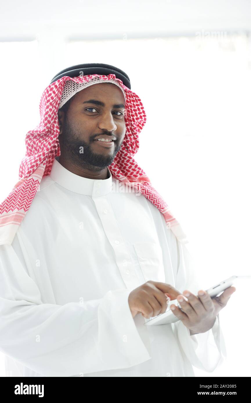 Middle eastern man with gulf clothes using tablet at office Stock Photo
