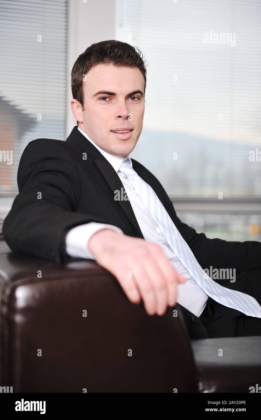 Businessman sitting on sofa in office Stock Photo