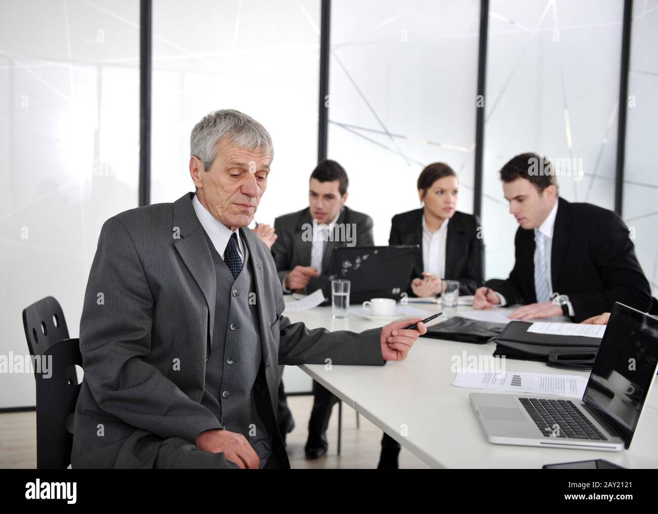 Senior businessman at a meeting. Group of colleagues in the background Stock Photo