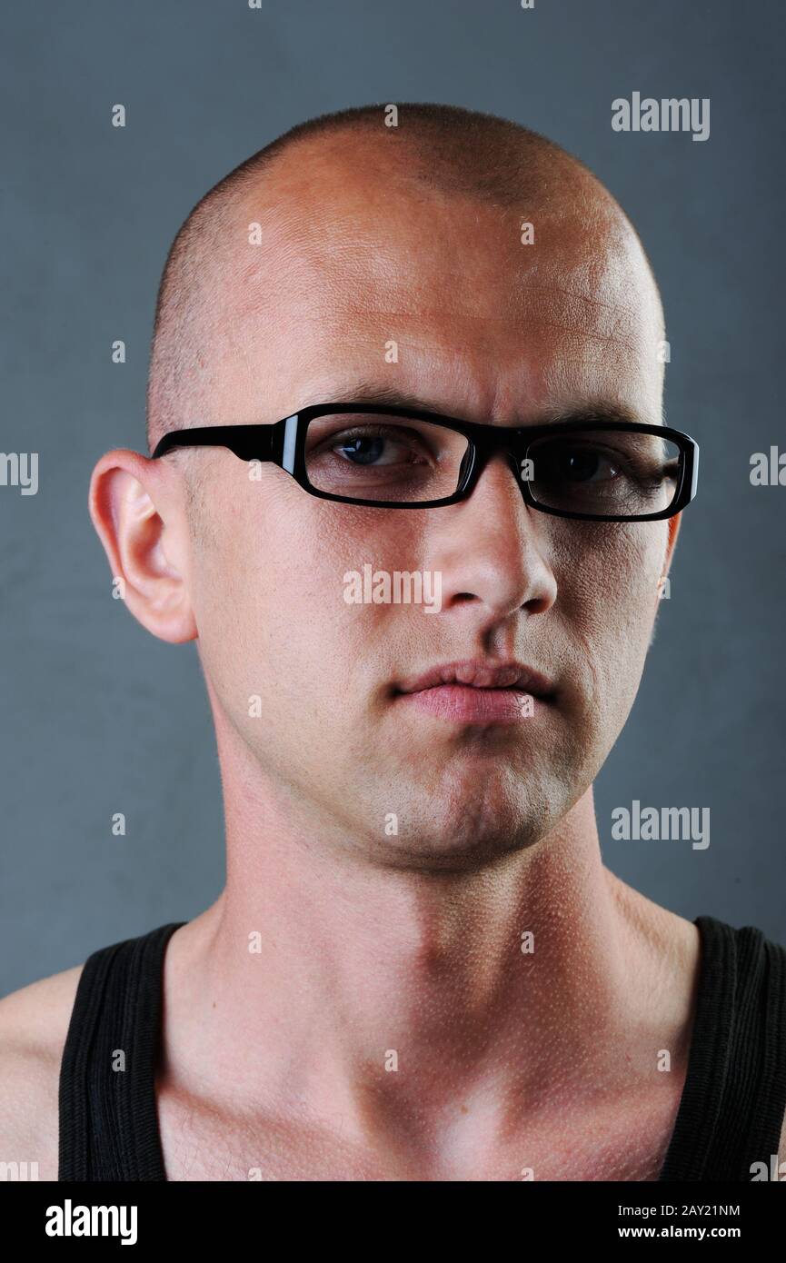 Bald man with glasses in his twenties Stock Photo. young girl texting on th...
