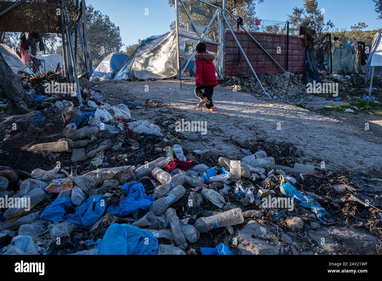 Child refugee walking of the gates from the play area, Moria Camp Lesbos Stock Photo