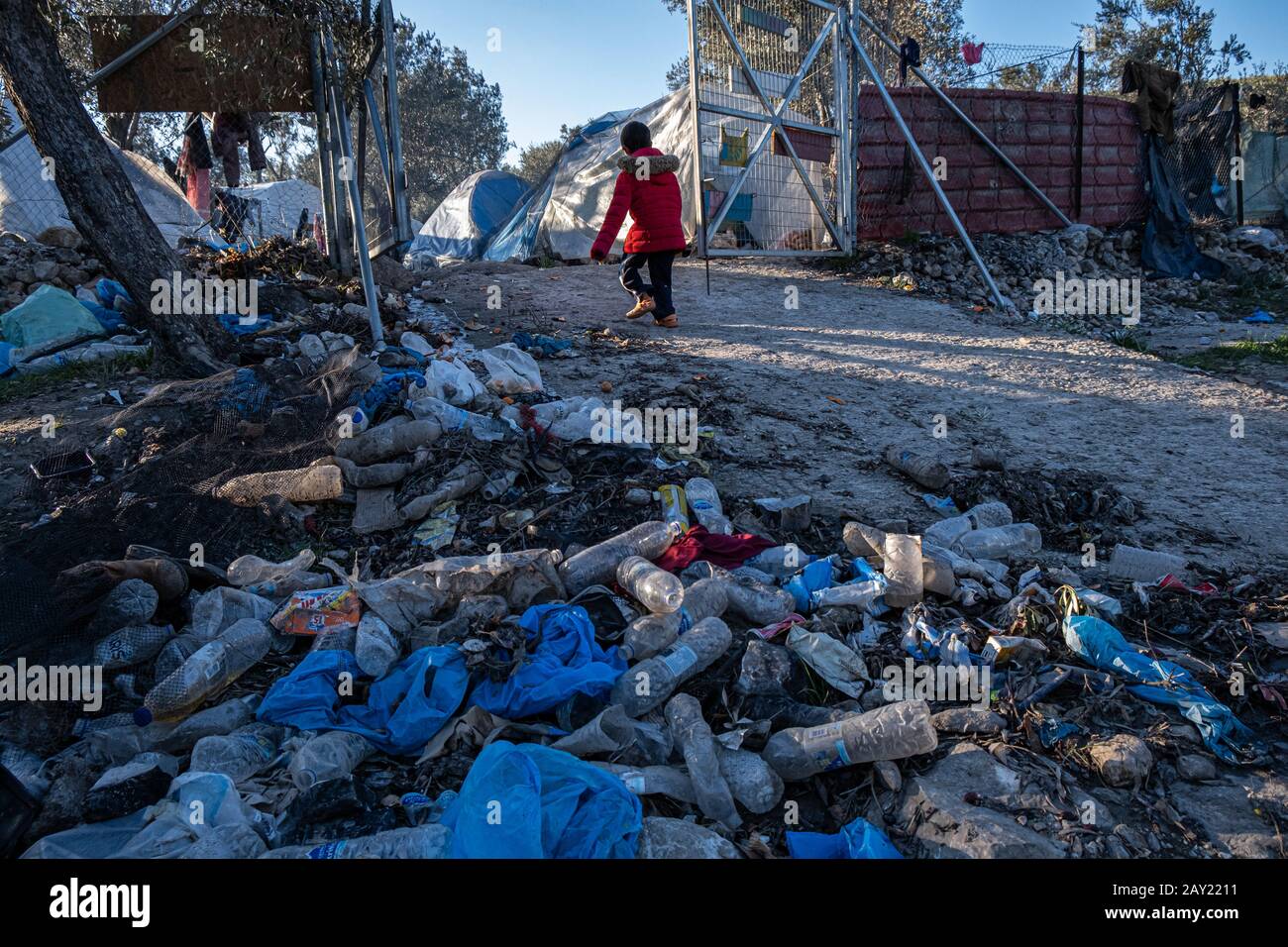 Child refugee walking of the gates from the play area, Moria Camp Lesbos Stock Photo