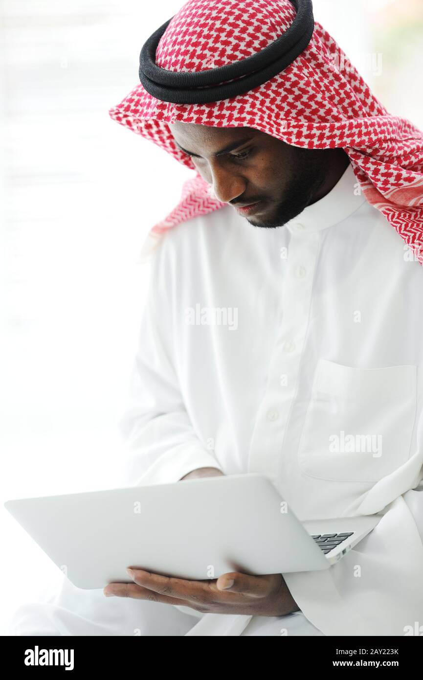 Black Arabic man working on laptop Stock Photo