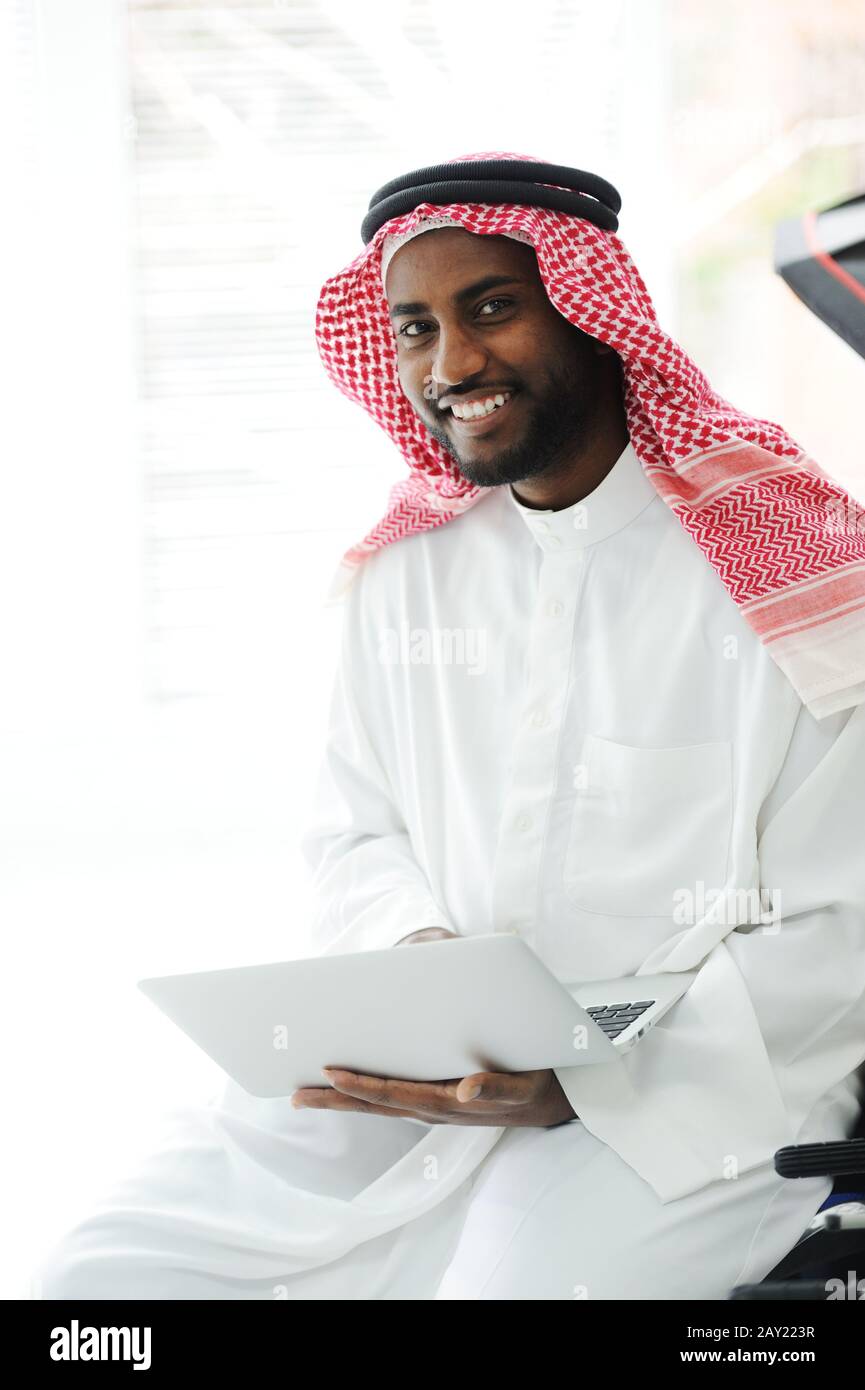 Black Arabic man working on laptop Stock Photo