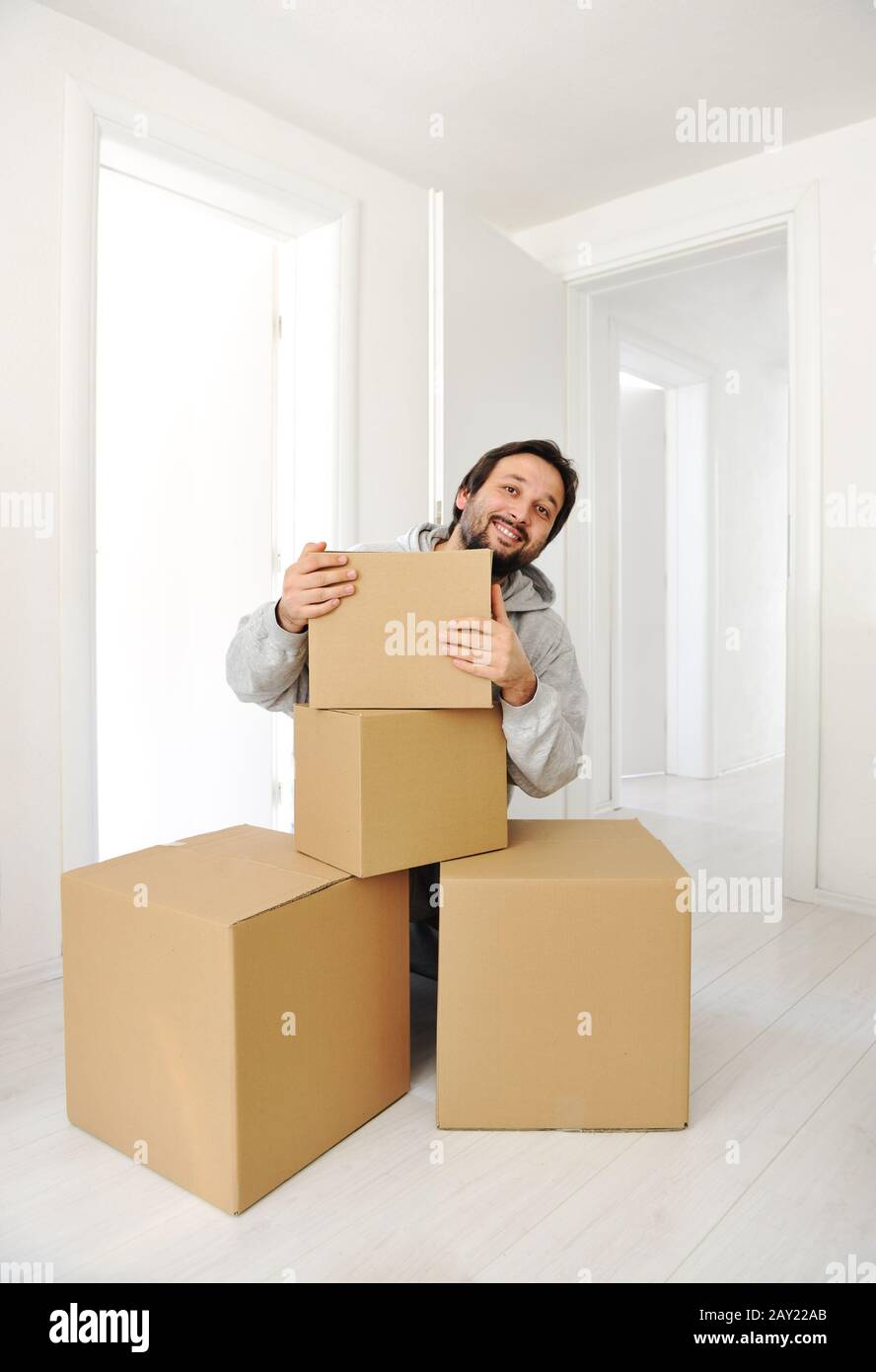 Man with boxes moving in new house Stock Photo