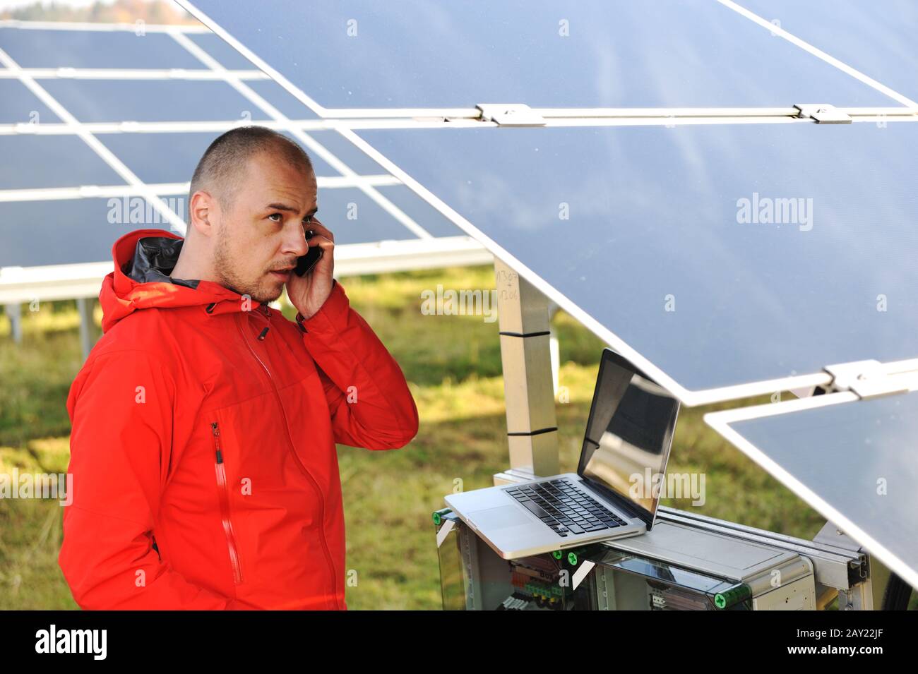 Engineer working with laptop by solar panels Stock Photo - Alamy