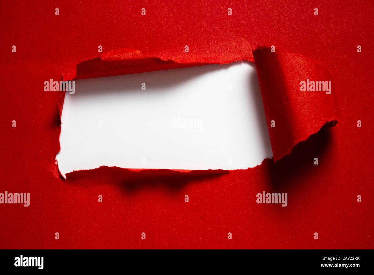 copyspace torn red paper with white background in the middle and hard shadows for pasting text Stock Photo
