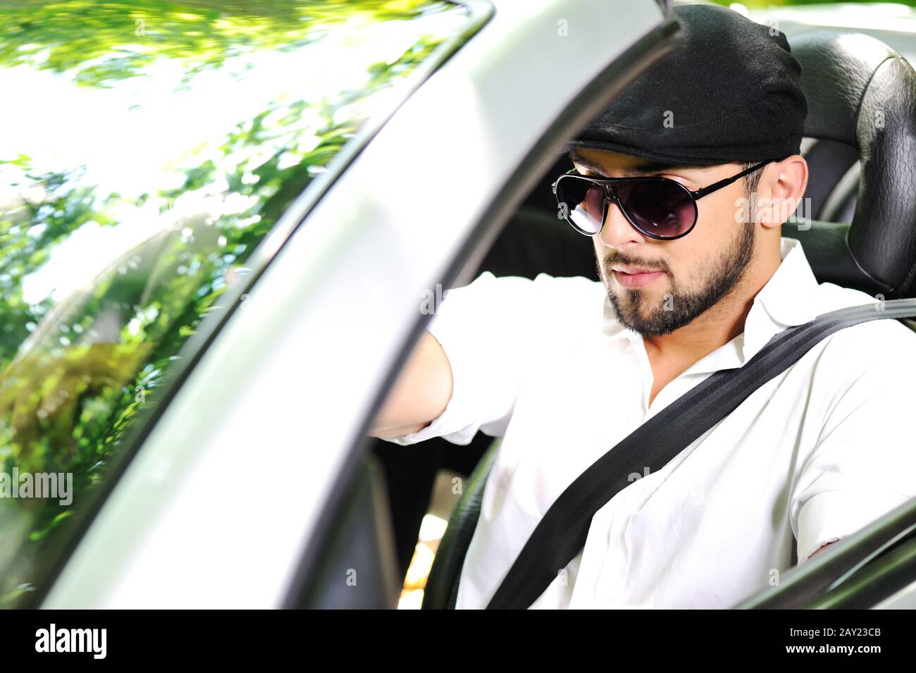 Young man driving a car with Stock Photo
