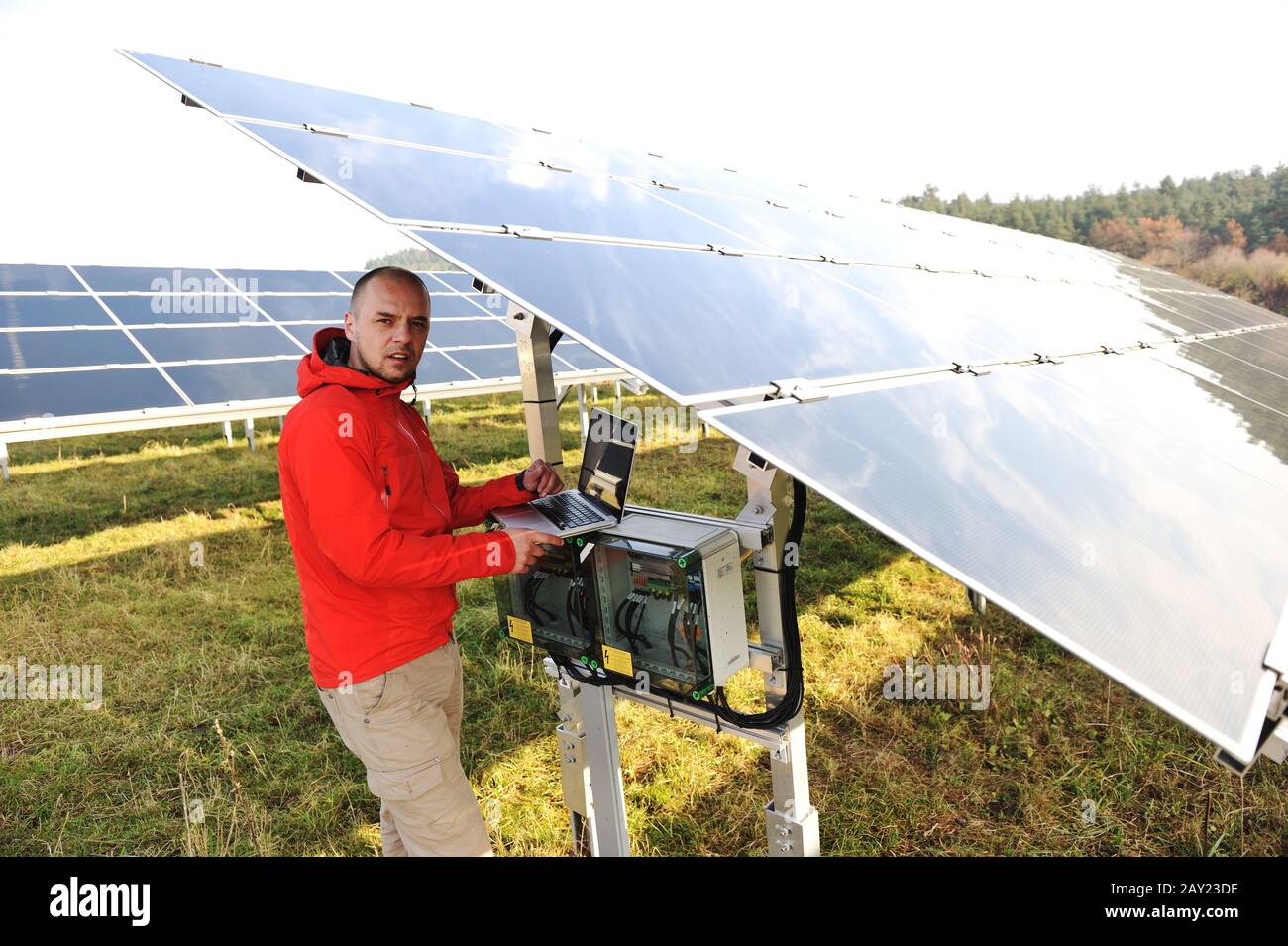 Engineer working with laptop by solar panels Stock Photo - Alamy