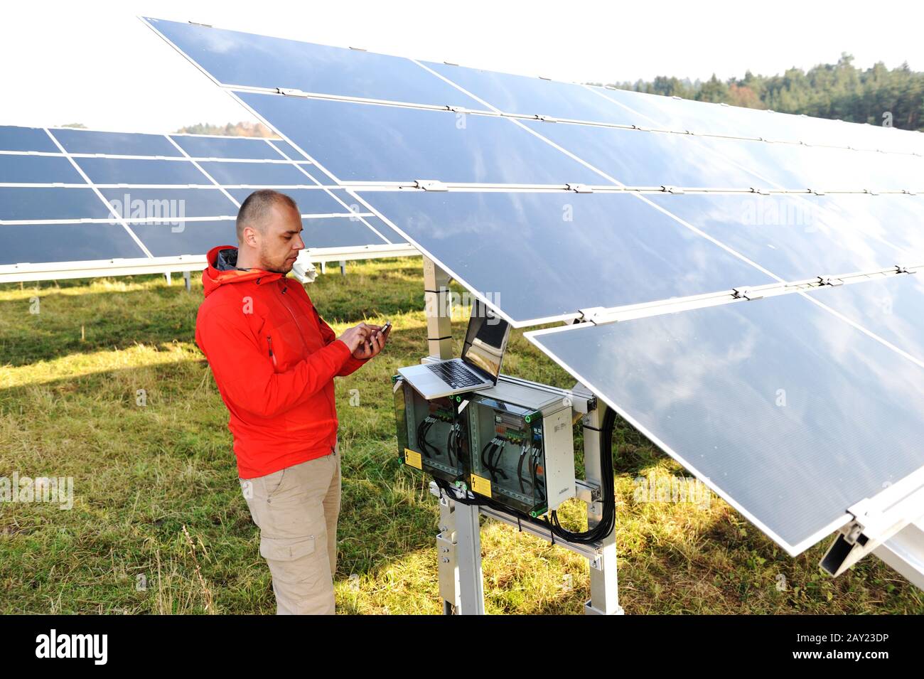 Engineer working with laptop by solar panels Stock Photo - Alamy