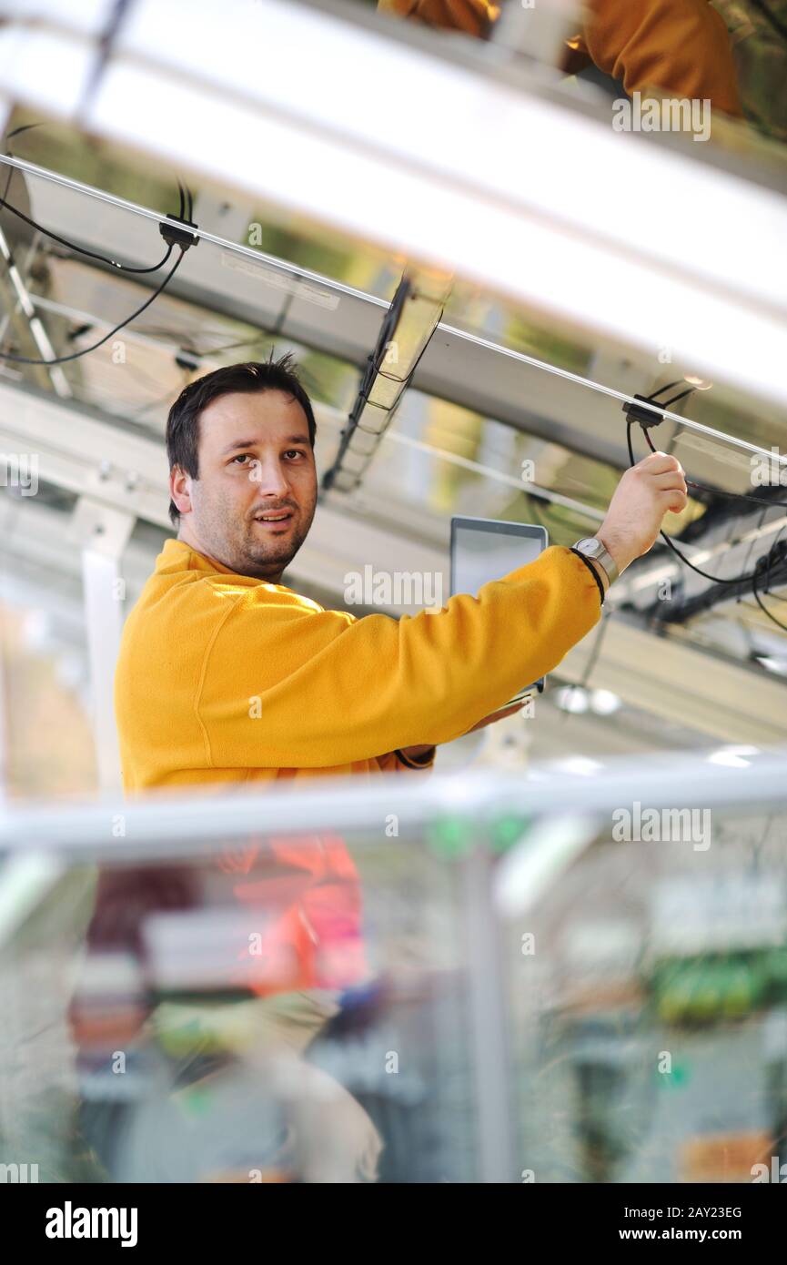 Young expert working at solar panels Stock Photo