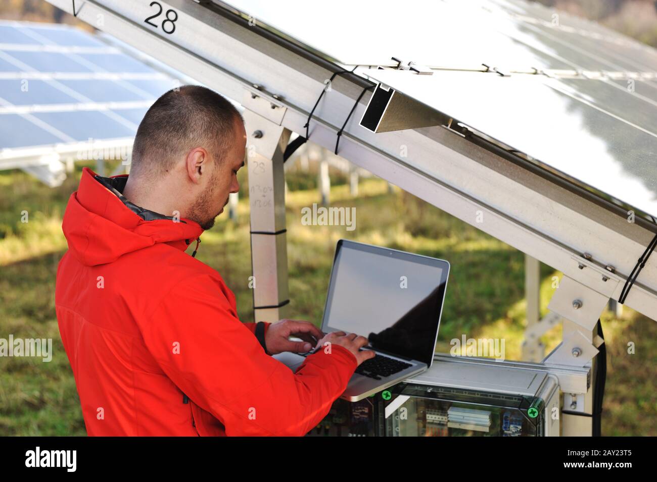 Engineer working with laptop by solar panels Stock Photo - Alamy