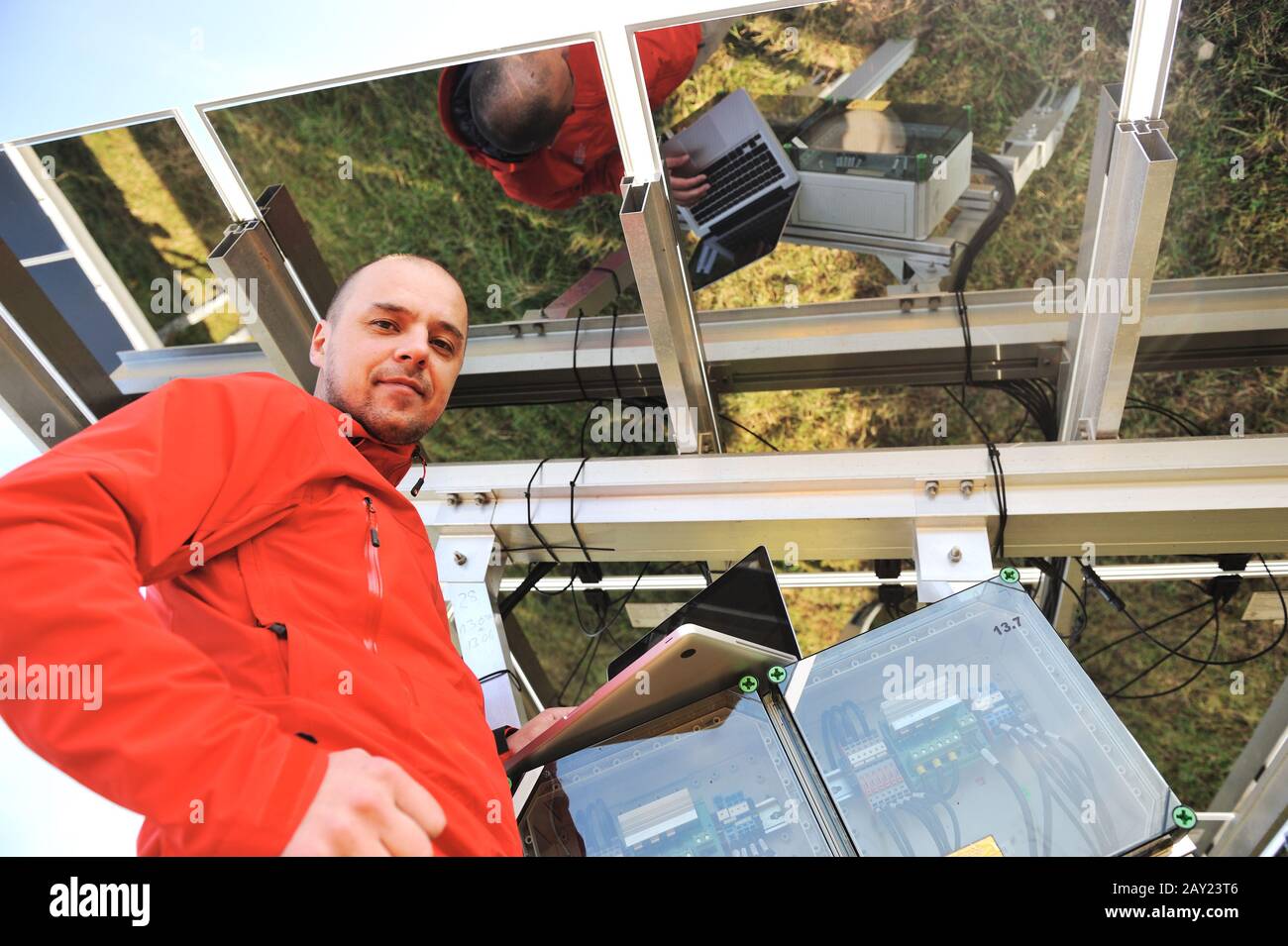 Engineer working with laptop fixing solar panels Stock Photo - Alamy