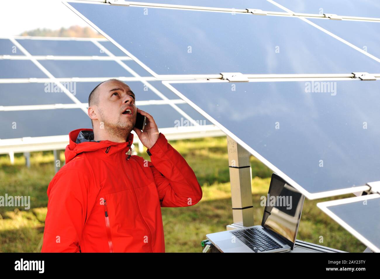 Engineer working with laptop by solar panels Stock Photo