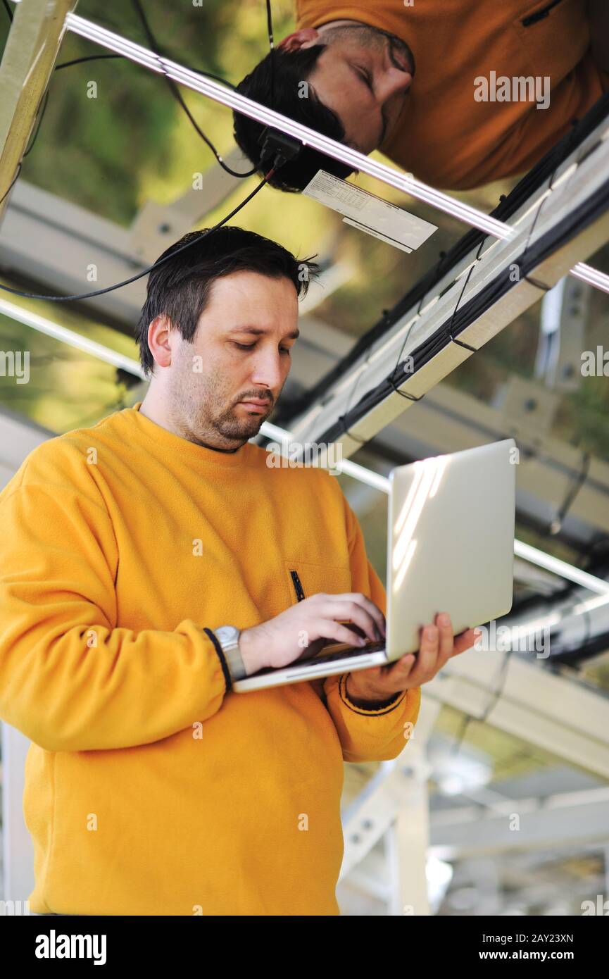 Engineer using laptop and connecting wires at work place Stock Photo