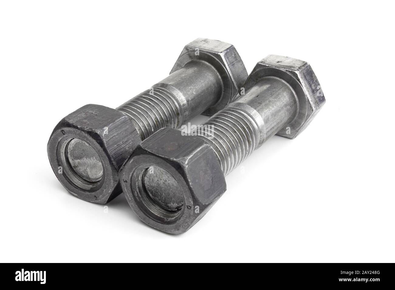 Two industrial screws with nuts lie isolated on white background. Stock Photo