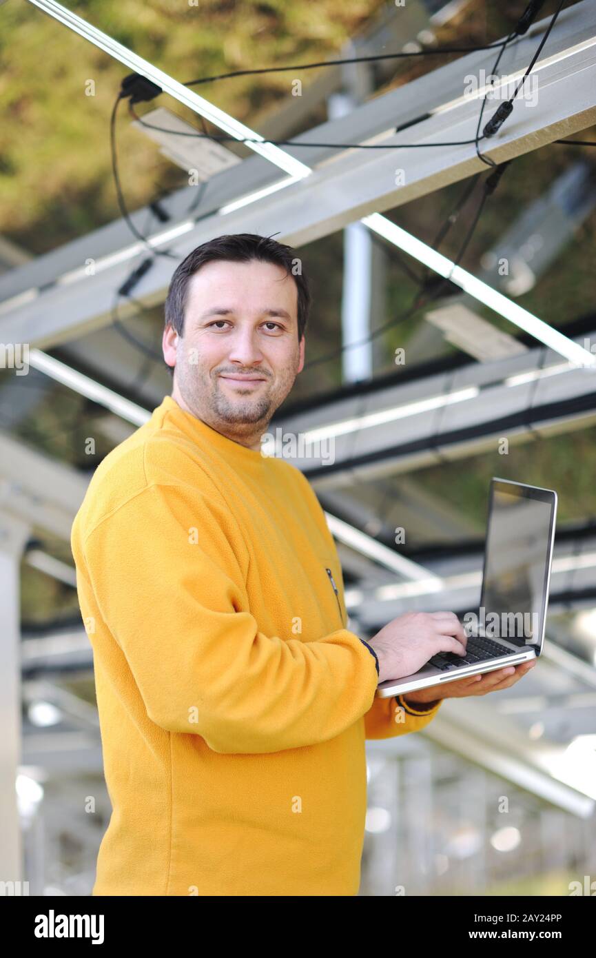 Engineer using laptop and connecting wires at work place Stock Photo