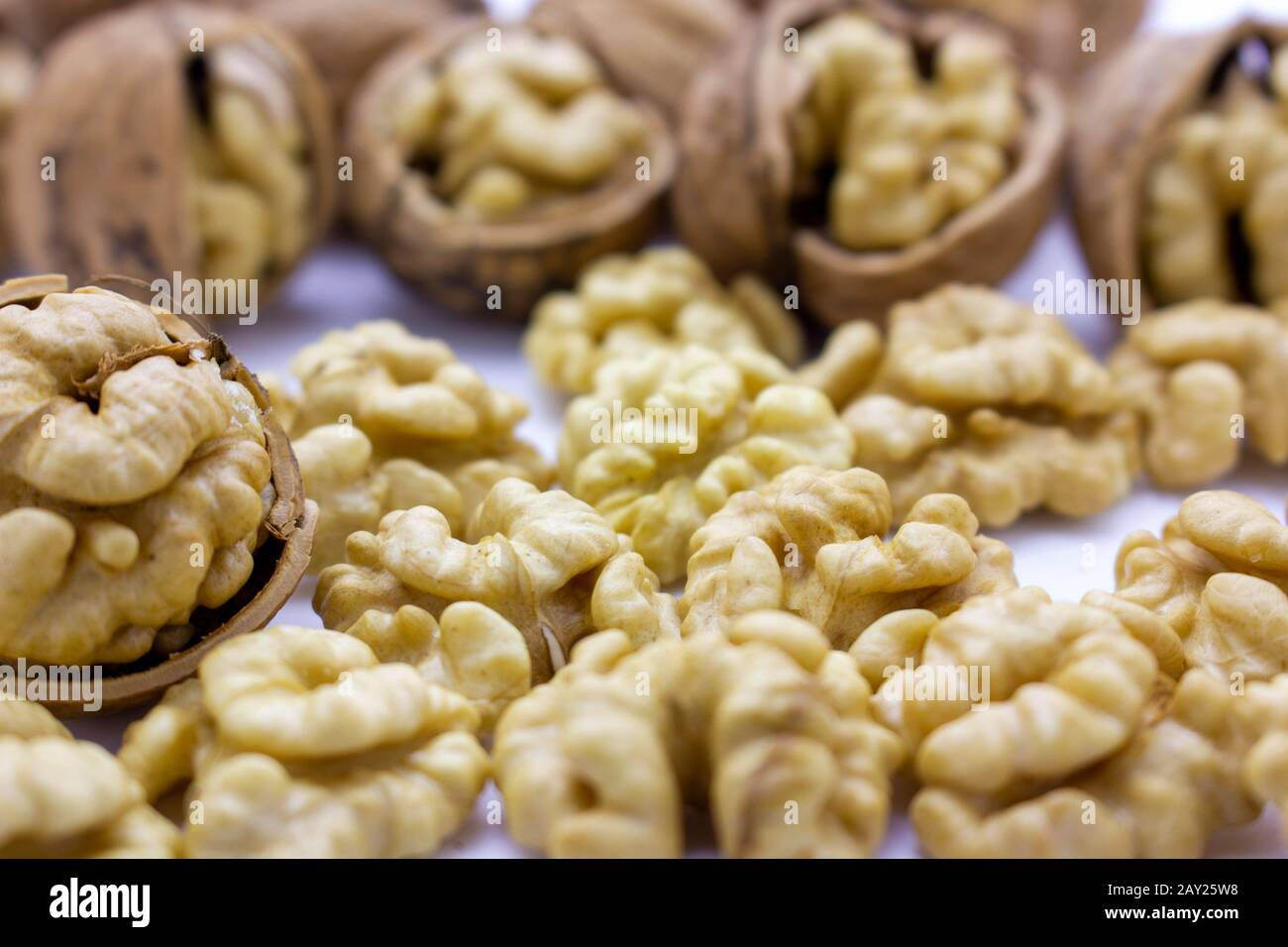 Peeled nuts. Walnuts, kernels and shells on a white background. Stock Photo