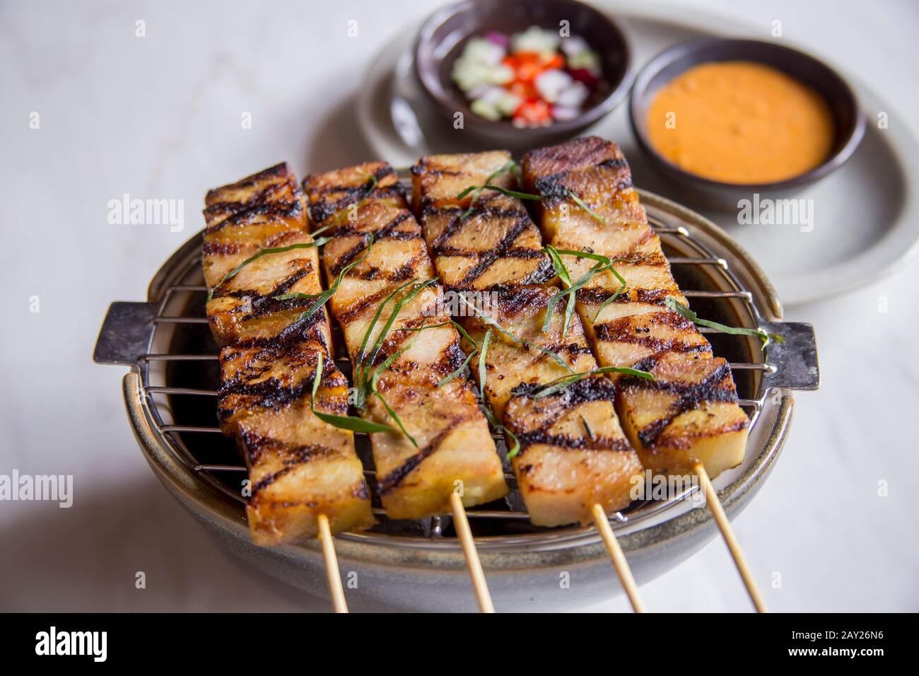 Thai food is characterized by lightly prepared dishes with Sataaromatic components and a spicy edge. This is pork satay with vinegar and peanut sauce. Stock Photo