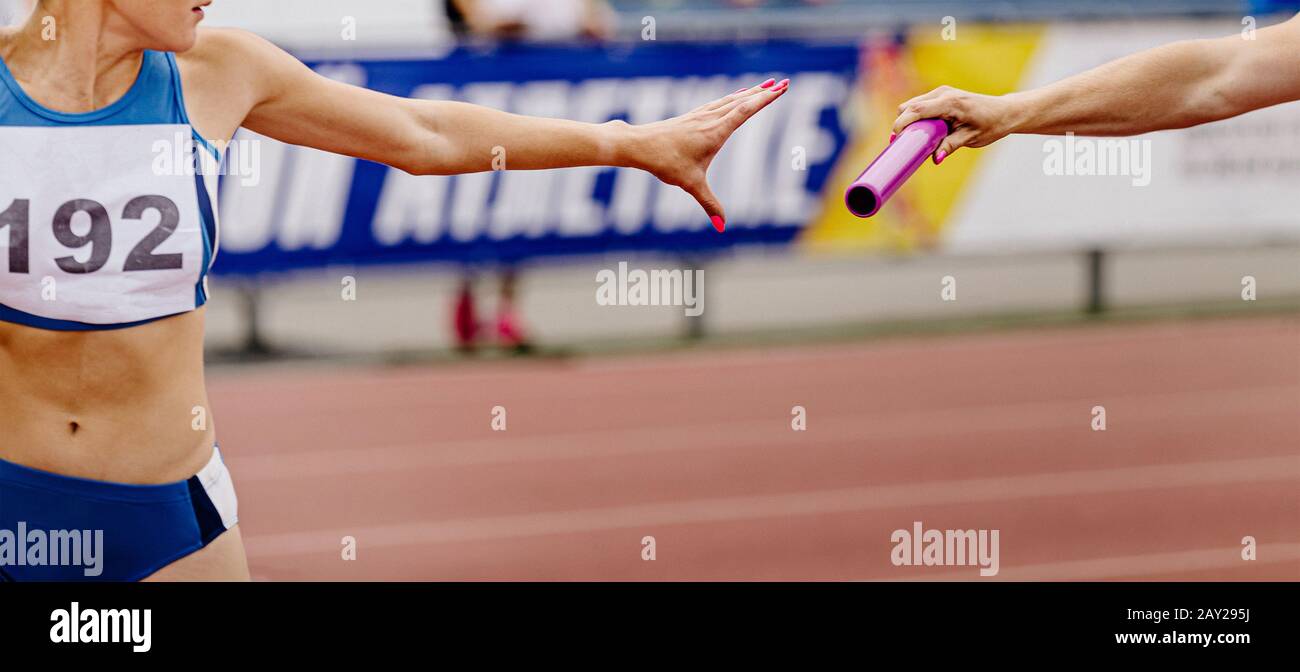 women relay team passing of baton in track and field Stock Photo Alamy